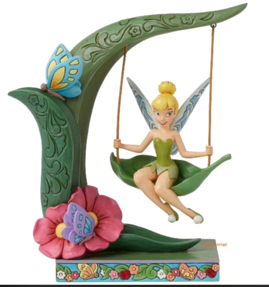 "Handbeschilderde Disney Traditions Tinkerbell Spring Swing figurine van Jim Shore, zittend op een schommel tussen bloesems, met sprankelende vleugels en vrolijke uitstraling in folk-art stijl – perfect als lente-decoratie of cadeau voor Disney-liefhebbers."