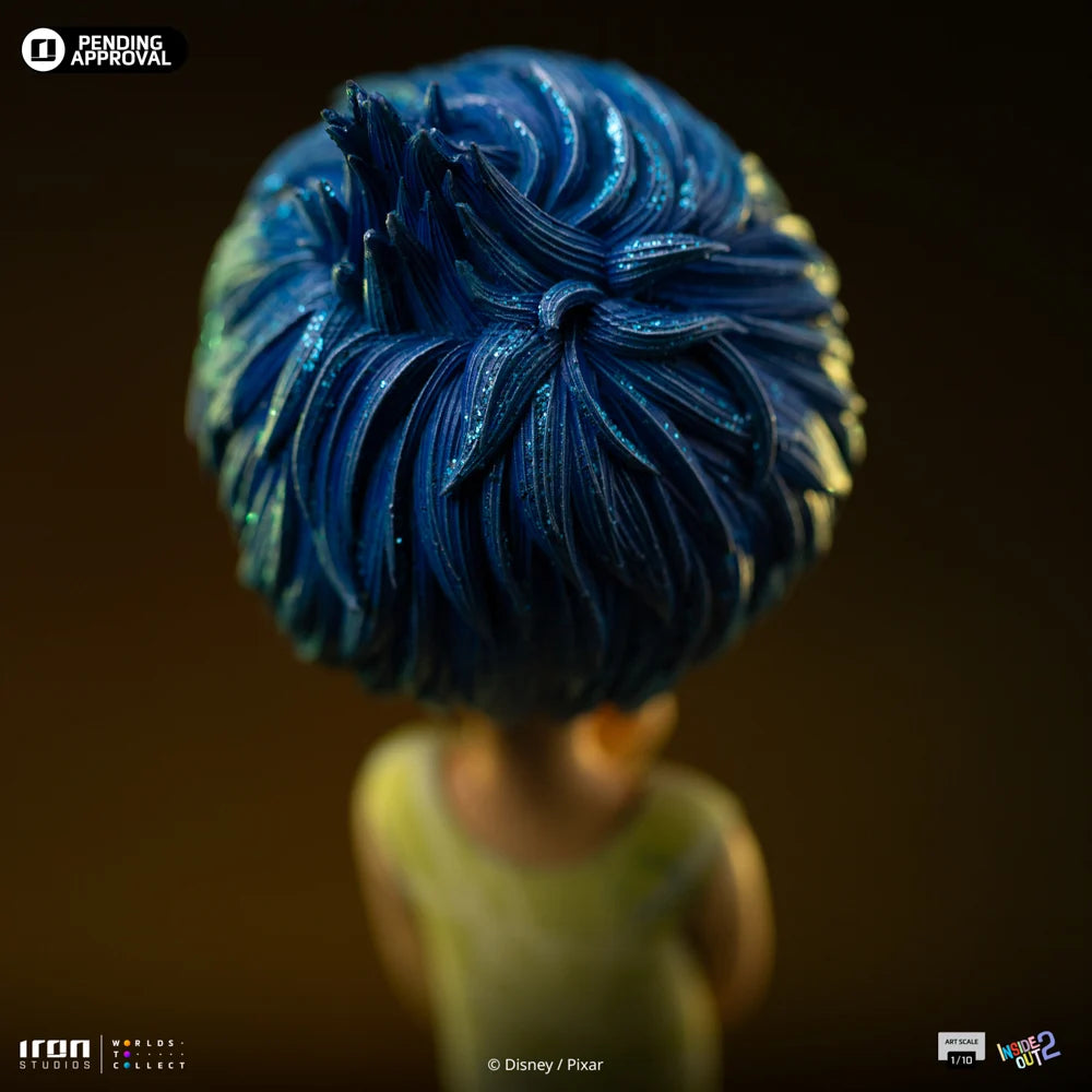 Beeldje van Joy op een kleurrijke sokkel, met sprankelend blauw haar en haar iconische gele jurk.