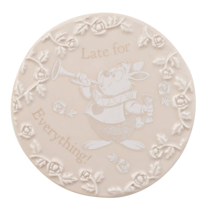 "Ronde onderzetters met scènes uit Alice in Wonderland, waaronder het theefeestje van de Mad Hatter en Alice's val in het konijnenhol."
