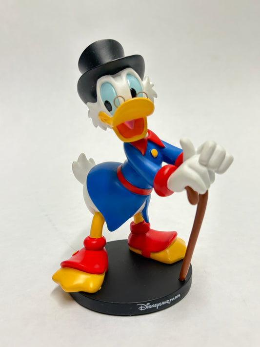 Dagobert Duck beeldje uit Disneyland Parijs in klassieke pose met geldzak.