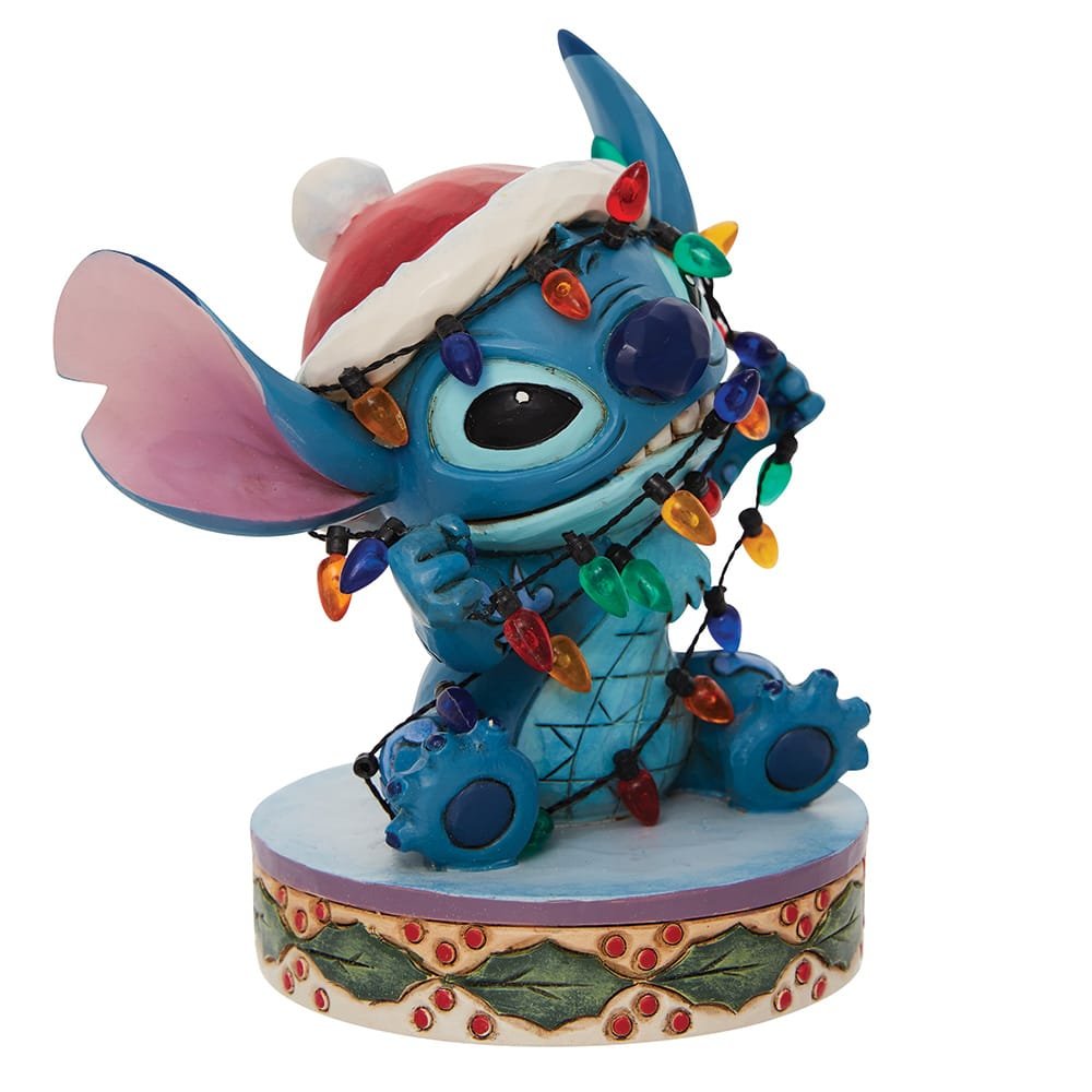 Jim Shore Disney-beeldje van Stitch met kerstmuts en lichtjes, een speels en feestelijk verzamelobject voor Disney-fans.