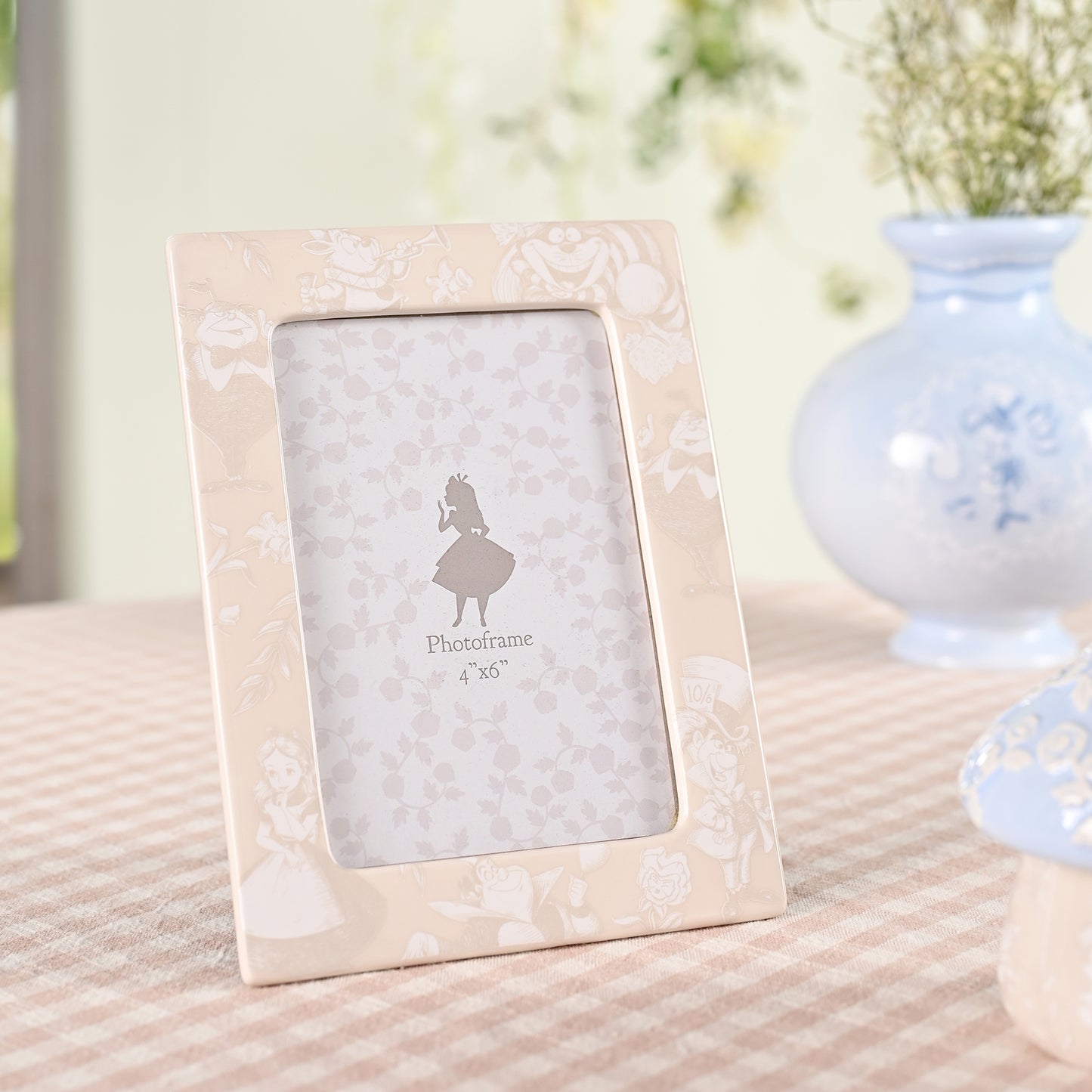 "Fotolijst met een speels ontwerp van Alice in Wonderland, met afbeeldingen van het theefeestje en andere bekende momenten uit het verhaal."