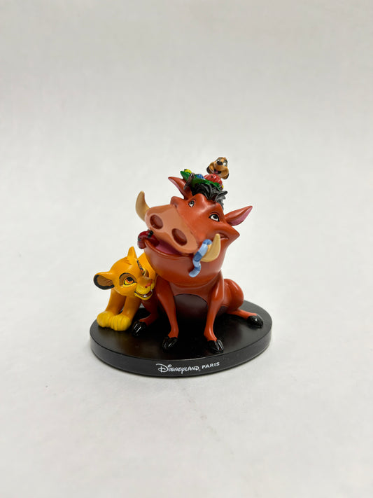 Simba, Timon en Pumba beeldje uit Disneyland Parijs in vrolijke pose, vol kleur en detail.