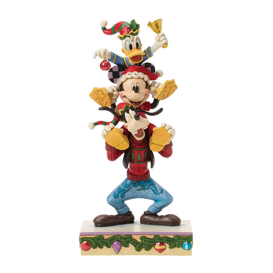 Disney Traditions A Holiday Pile Up toont Mickey, Donald en Goofy speels gestapeld in een kerstscène. Compact, gedetailleerd en perfect als Disney-verzamelobject of kerstdecoratie.