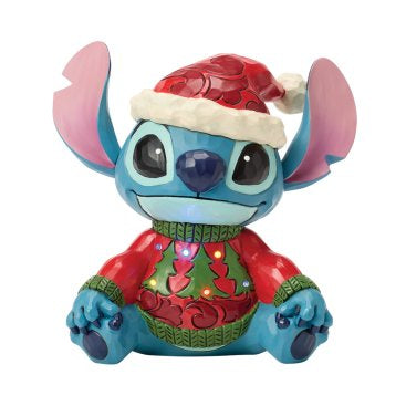 Disney Traditions Feeling Jolly and Naughty ‘Stitch Sweater LED’ toont Stitch in een vrolijke kersttrui met LED-verlichting. Perfect als kerstdecoratie of Disney-verzamelobject.