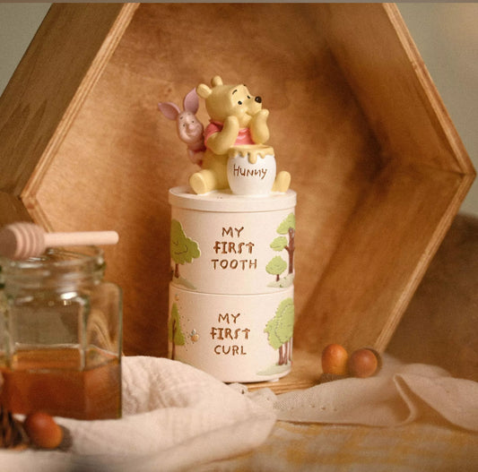 Witte stapelbare Winnie de Poeh tand- en krullen-sieradendoosjes met geperste ‘My first’ teksten en kleurrijke decoraties.