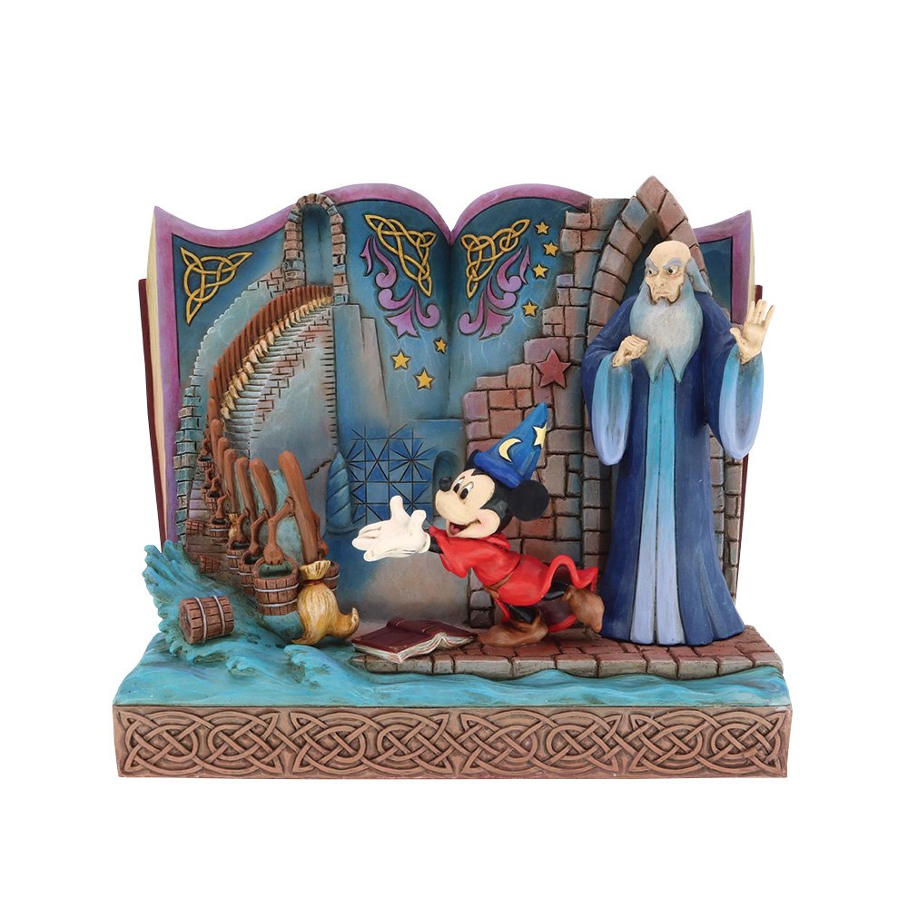 Betoverend Jim Shore-beeldje van Fantasia met Mickey Mouse als tovenaar die bezems betovert, terwijl mentor Yen Sid toekijkt, vormgegeven binnen de pagina’s van een open verhaalboek — een uniek Disney-kunstwerk voor verzamelaars.