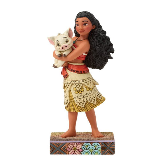 Enesco Jim Shore-beeldje van Moana die haar varkentje Pua omhelst op een zandkleurig podium, versierd met levendige kleuren en verfijnde patronen.